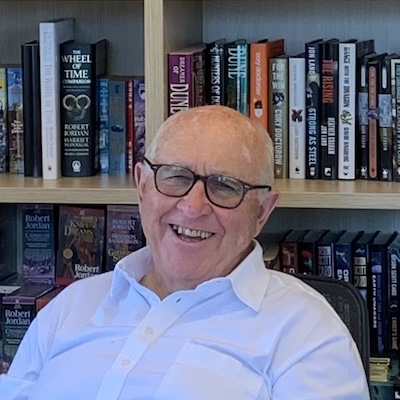 Tom Doherty, head shot with bookshelf in background